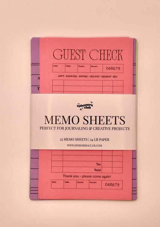 A pink memo sheet set with purple and green tabs, wrapped in a white paper band that reads 'Memo Sheets' and shows the brand 'The Paper Club'.