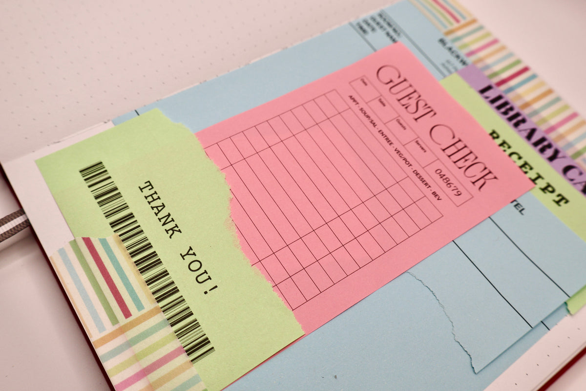 A close-up of a colorful stationery set featuring a light pink guest check pad, a light green thank you note with a barcode, and other matching receipt and ticket sheets.
